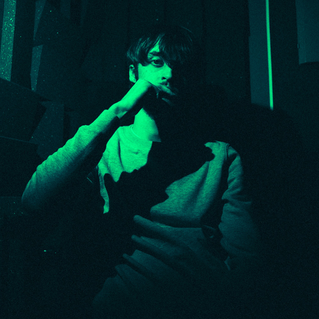 Arkz Beats, sitting in a green lit room