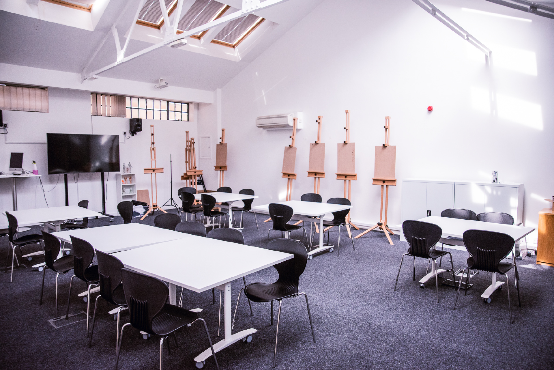 modern classroom with desks, chairs, tvs and clipboards