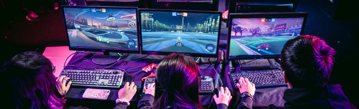 A group of people taking part in an esports tournament at a row of computers