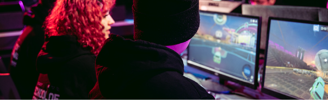 A group of people taking part in an esports tournament at a row of computers