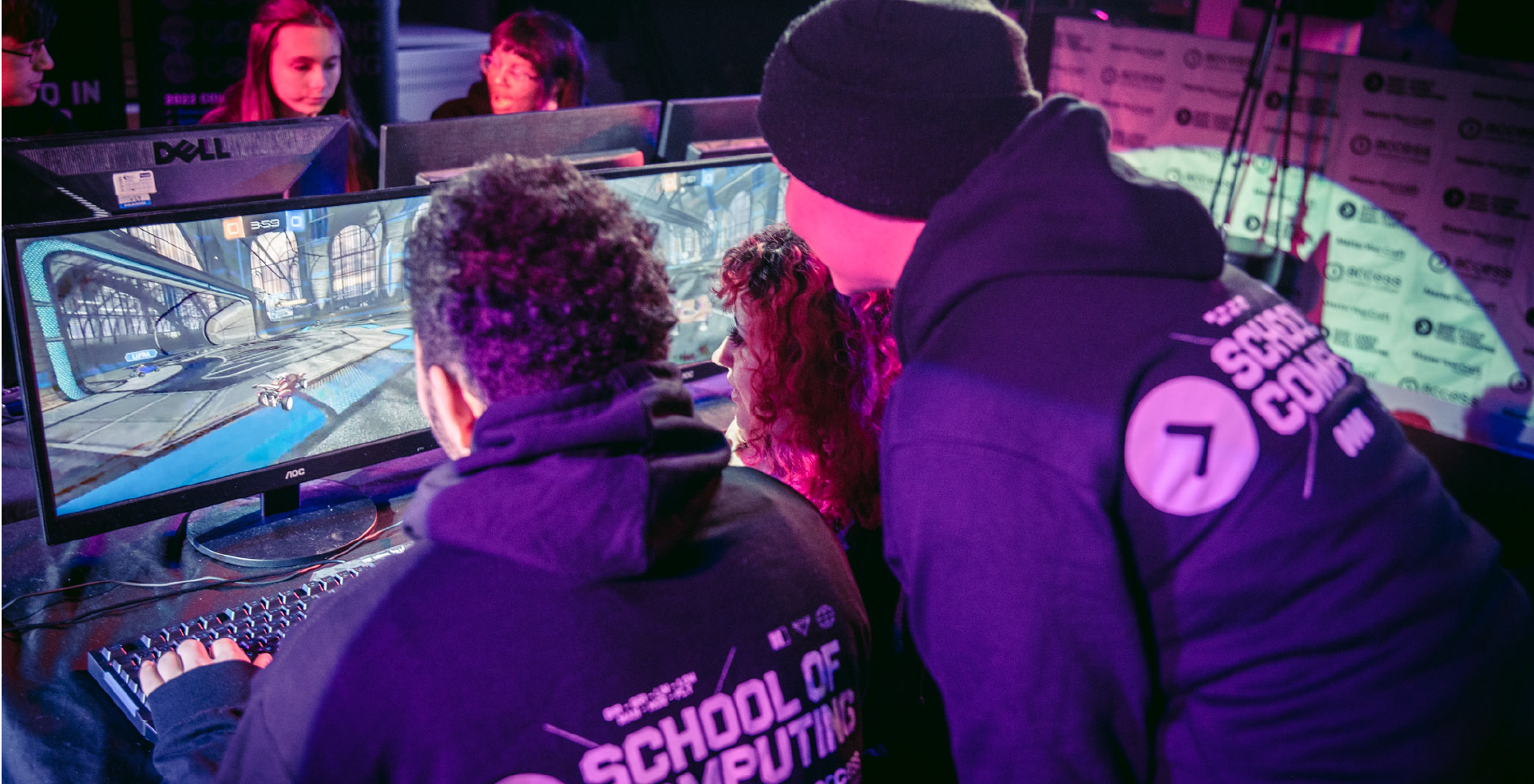 Two groups of people competing in esports tournament, at banks of computers