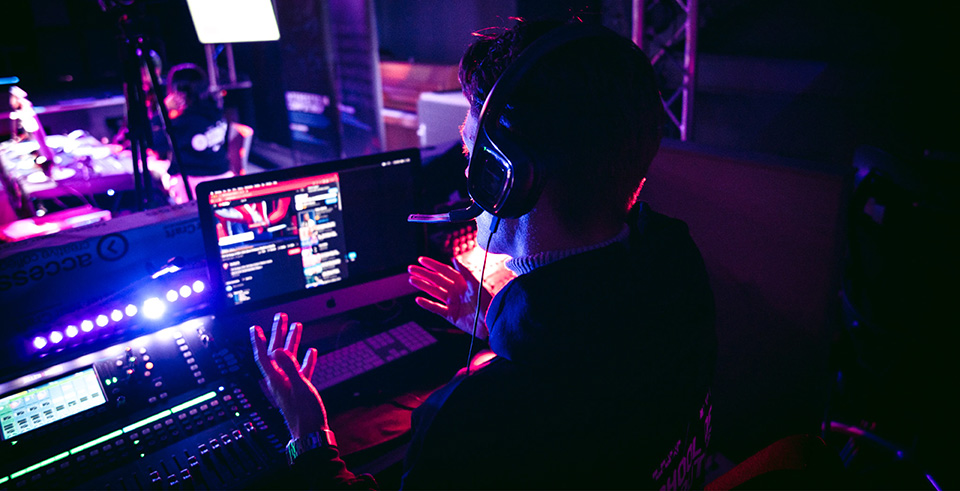A student behind a sound desk wearing a headset