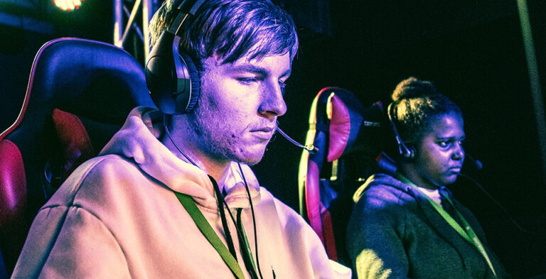 Two students in gaming chairs and headsets concentrating