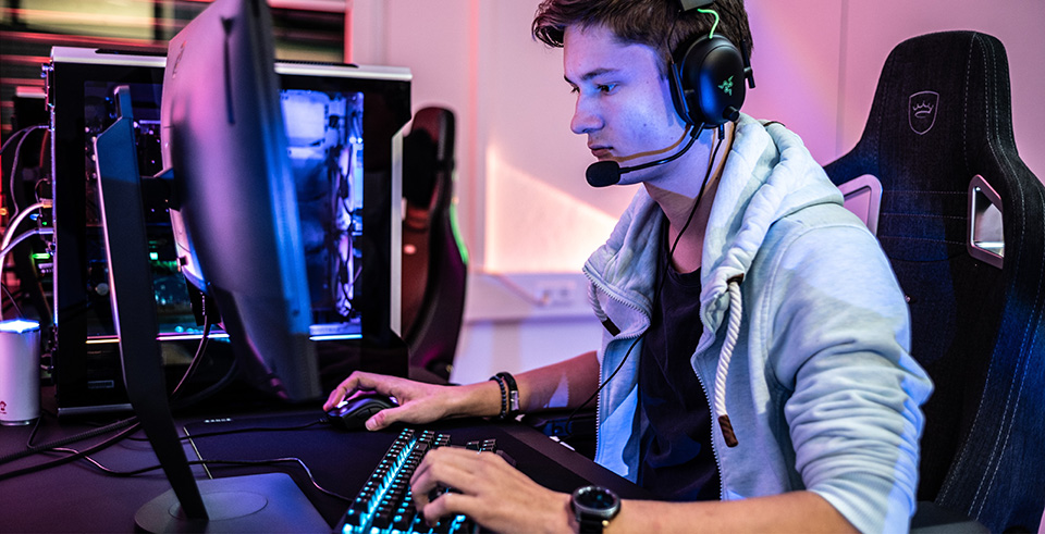 A male working at a computer wearing a headset