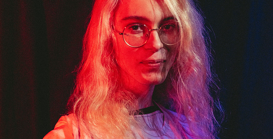 An image of a person wearing glasses on a black backdrop