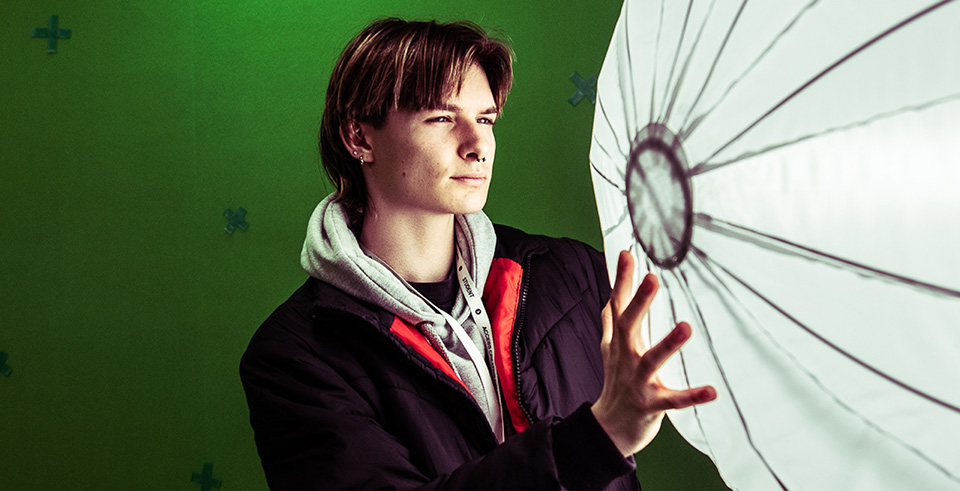 A media student adjusting lighting