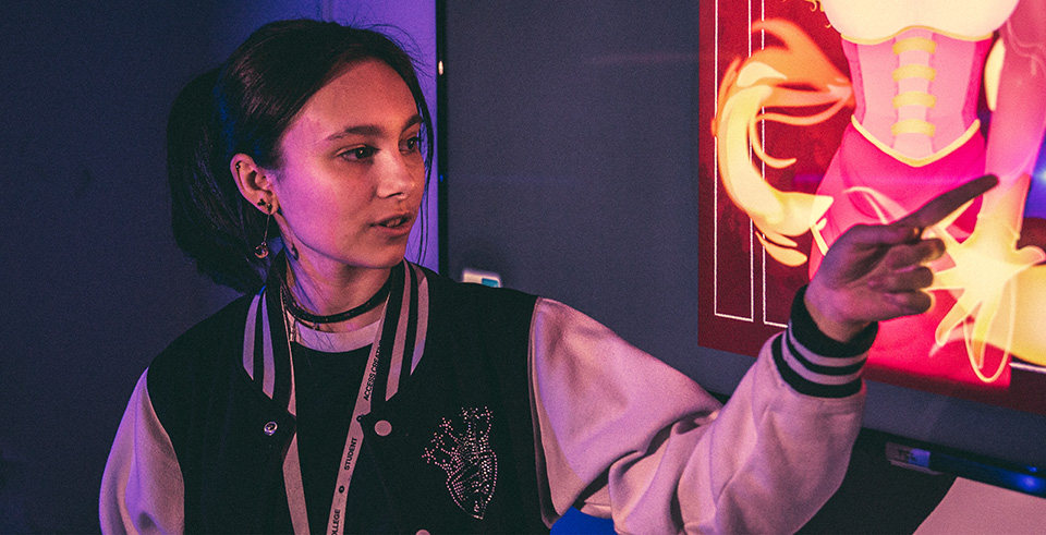 A female pointing at projected artwork