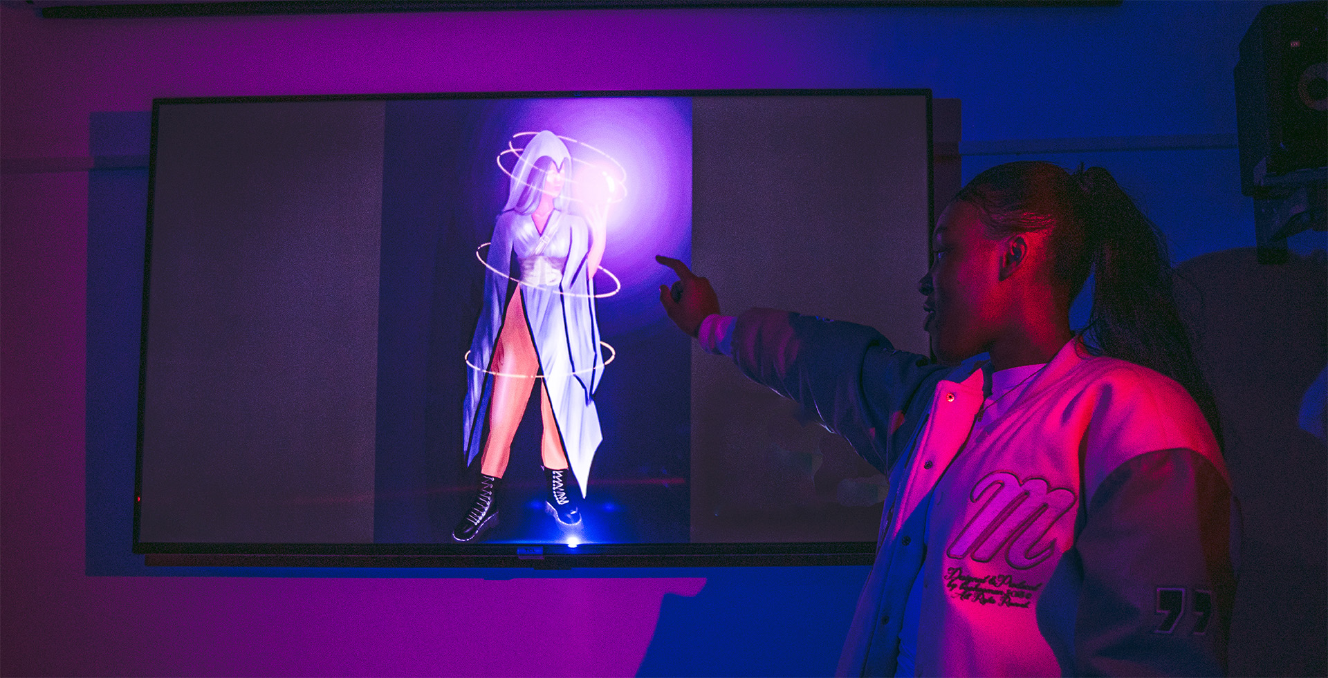 A person pointing to an art piece on a screen
