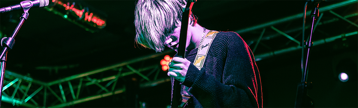 A male playing guitar on stage