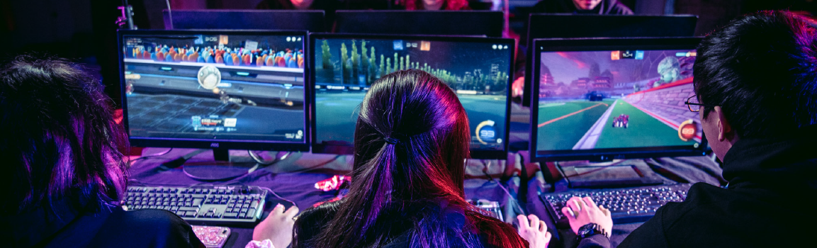A group of people participating in an esports tournament at a row of computers