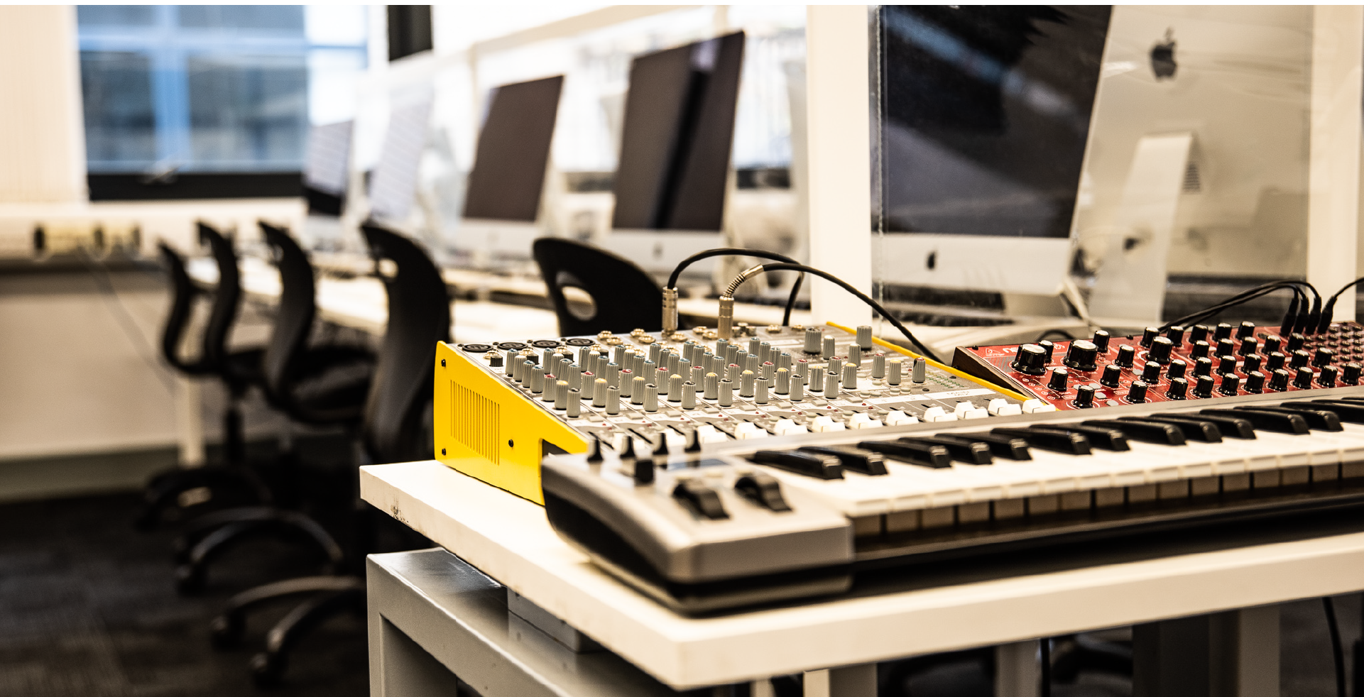 Image of computers, mixing consoles and MIDI keyboards in a classroom