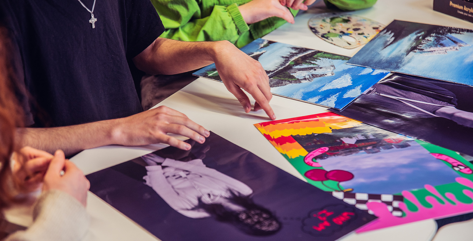 A group of people looking at printed images on a desk