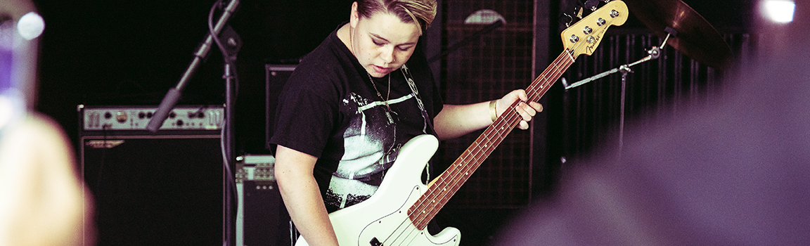A person playing bass guitar on stage