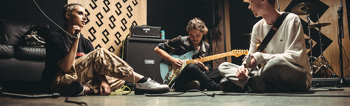 A band sat on the floor playing music together