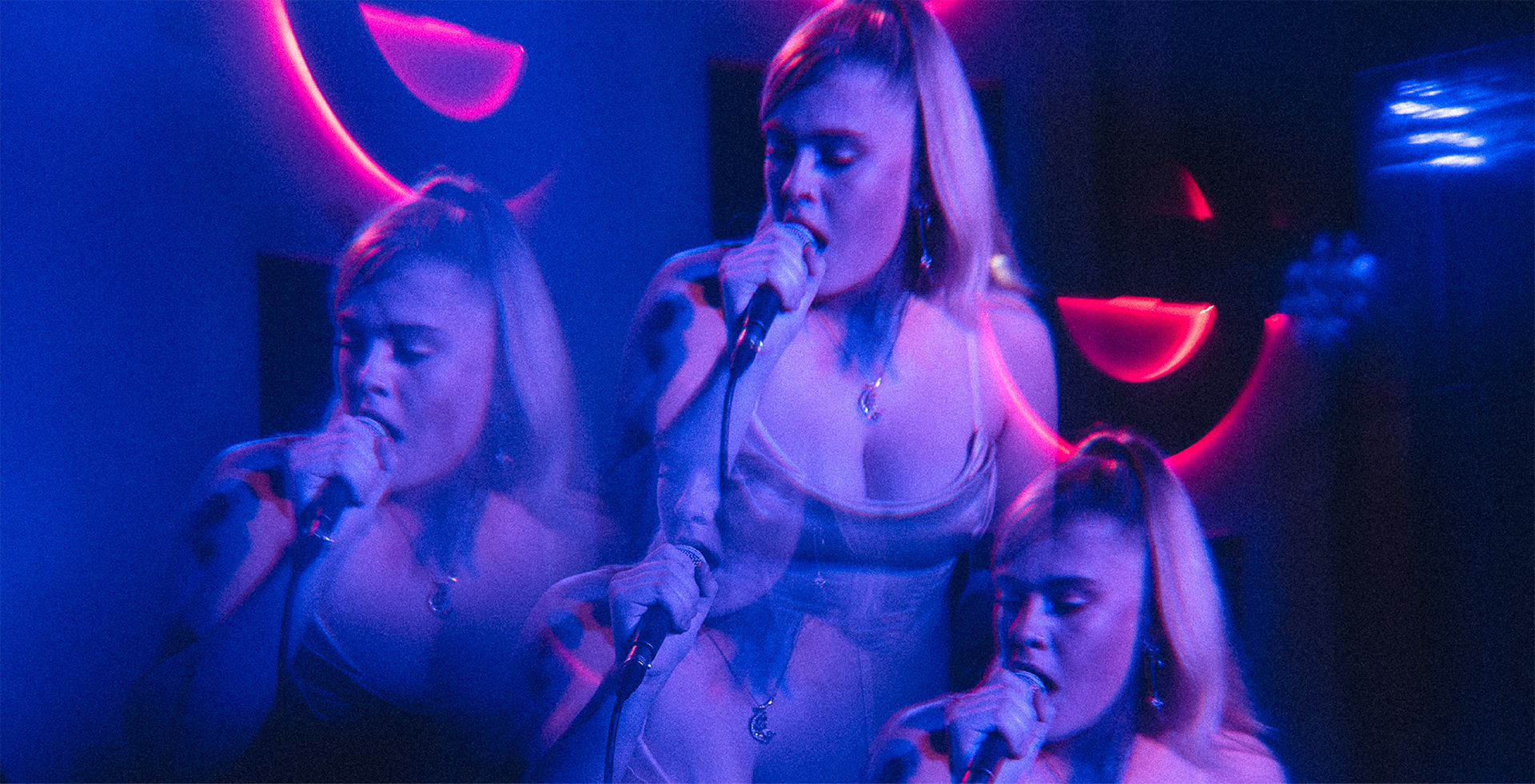 A blue tinged, edited image of a female performing