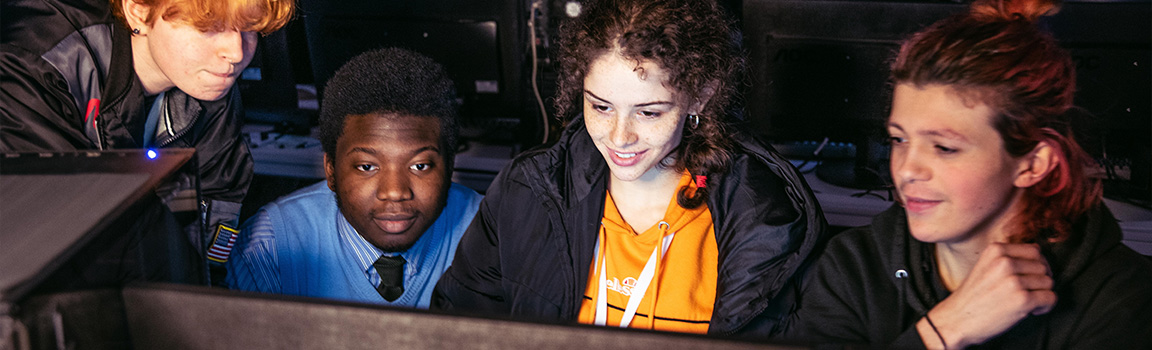 A group of people gathered at a computer