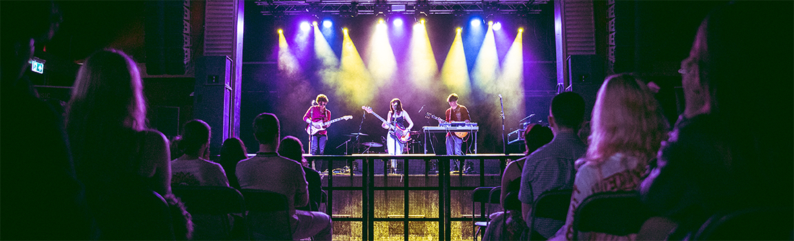 A crowd watching a band perform on stage