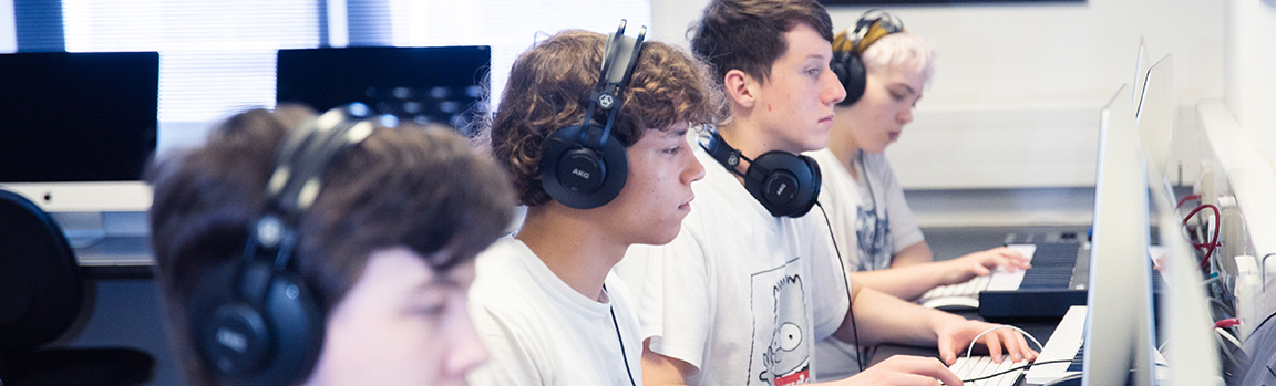 A group of people working at computers with MIDI keyboards