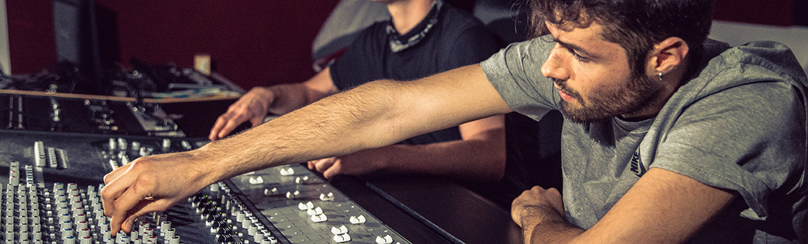A male working at a music mixing desk