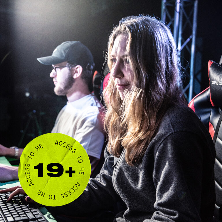 Two people sat in gaming chairs at computers