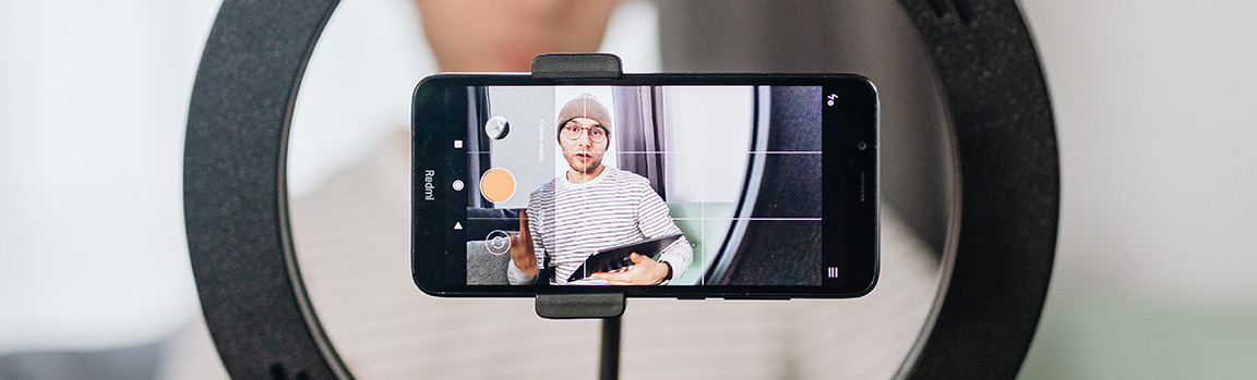 A photo of a phone screen with a person talking into the phone, holding a tablet