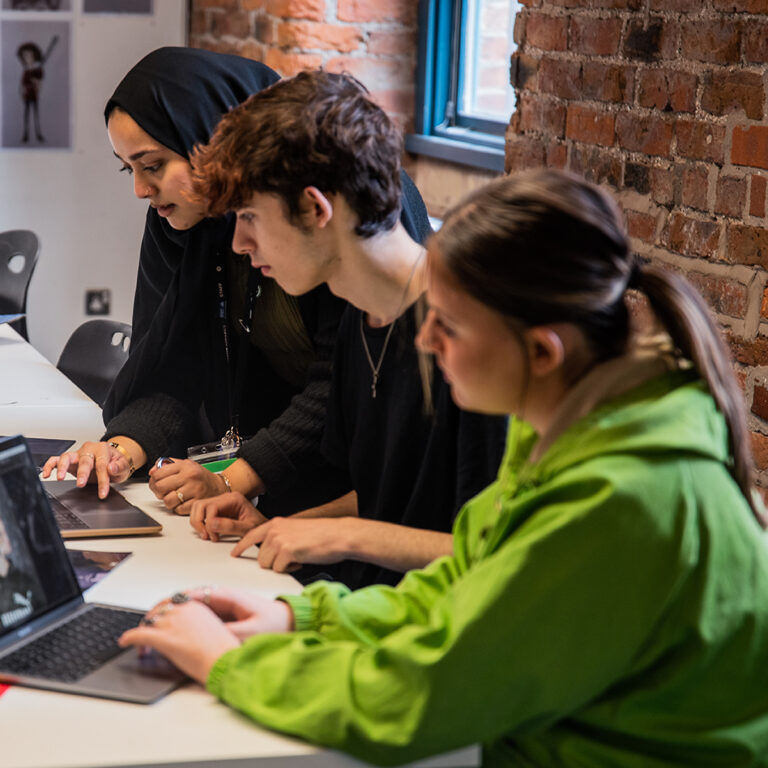 Three people working at computers