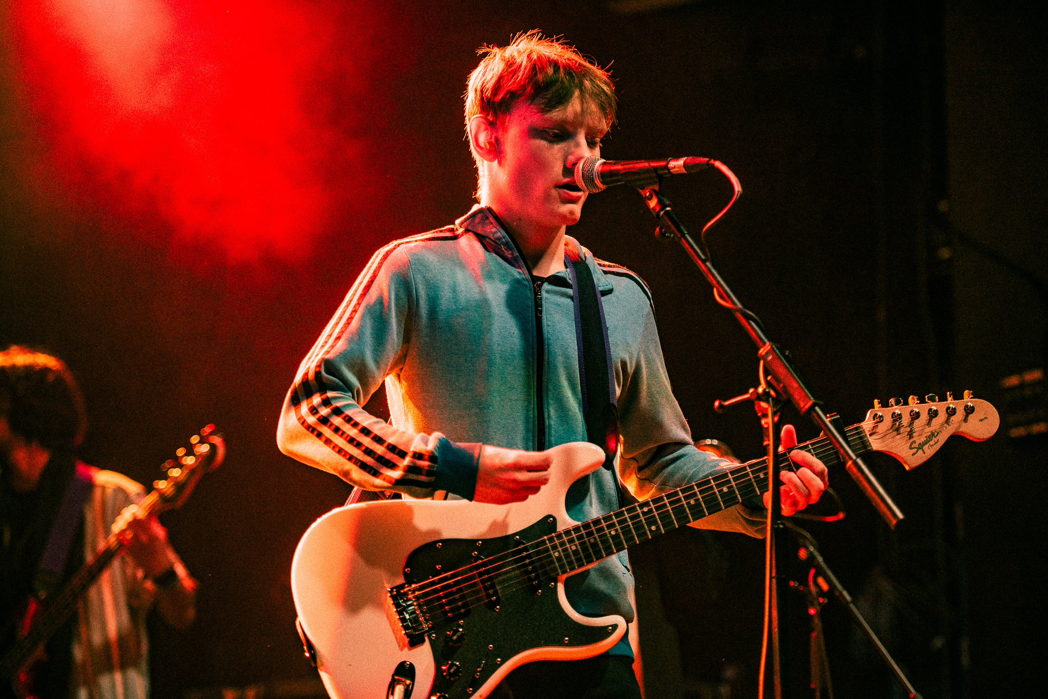 Music performance student playing guitar and singing on stage