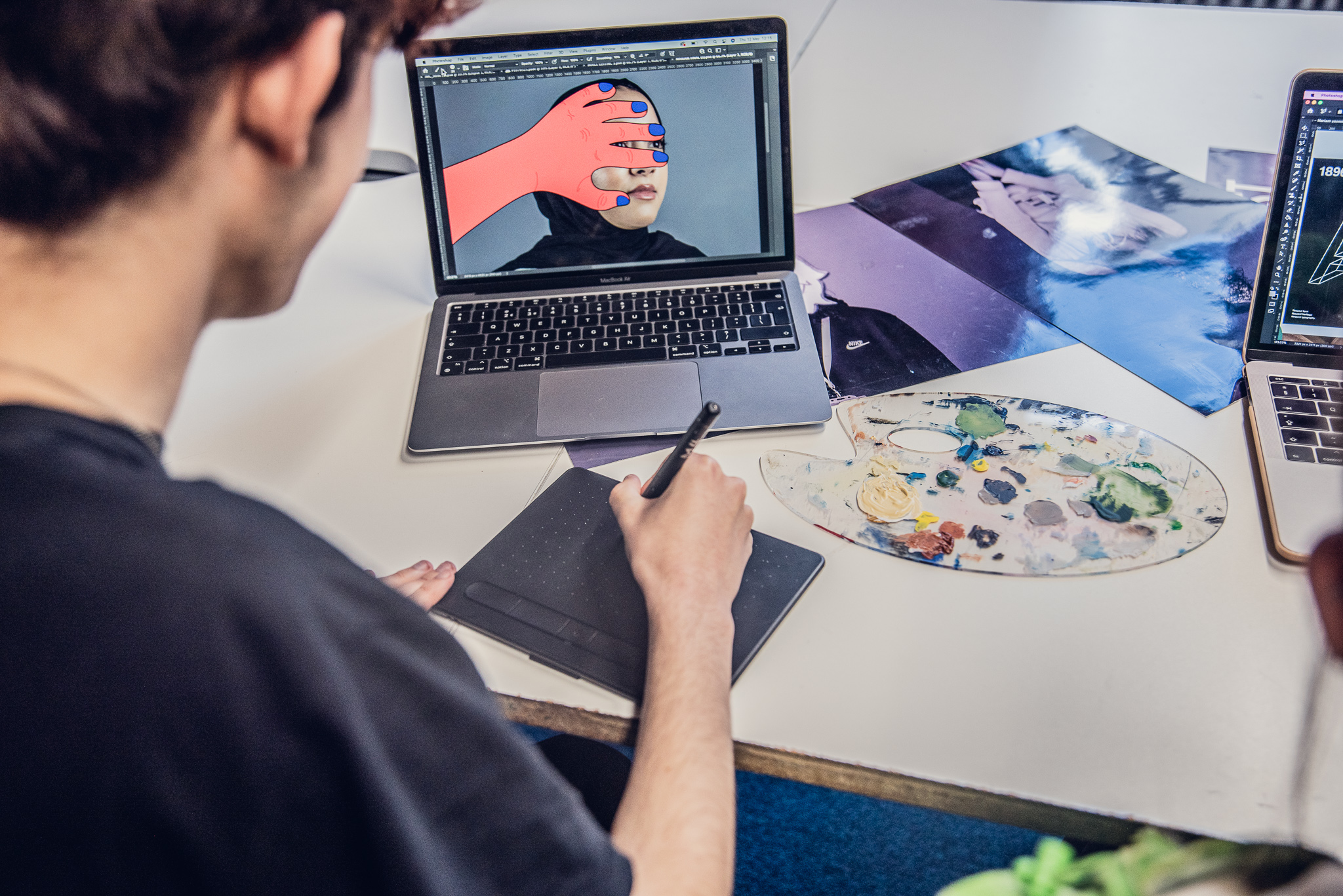 Graphic design student editing an image of a cartoon hand over a real woman's face, using a tablet
