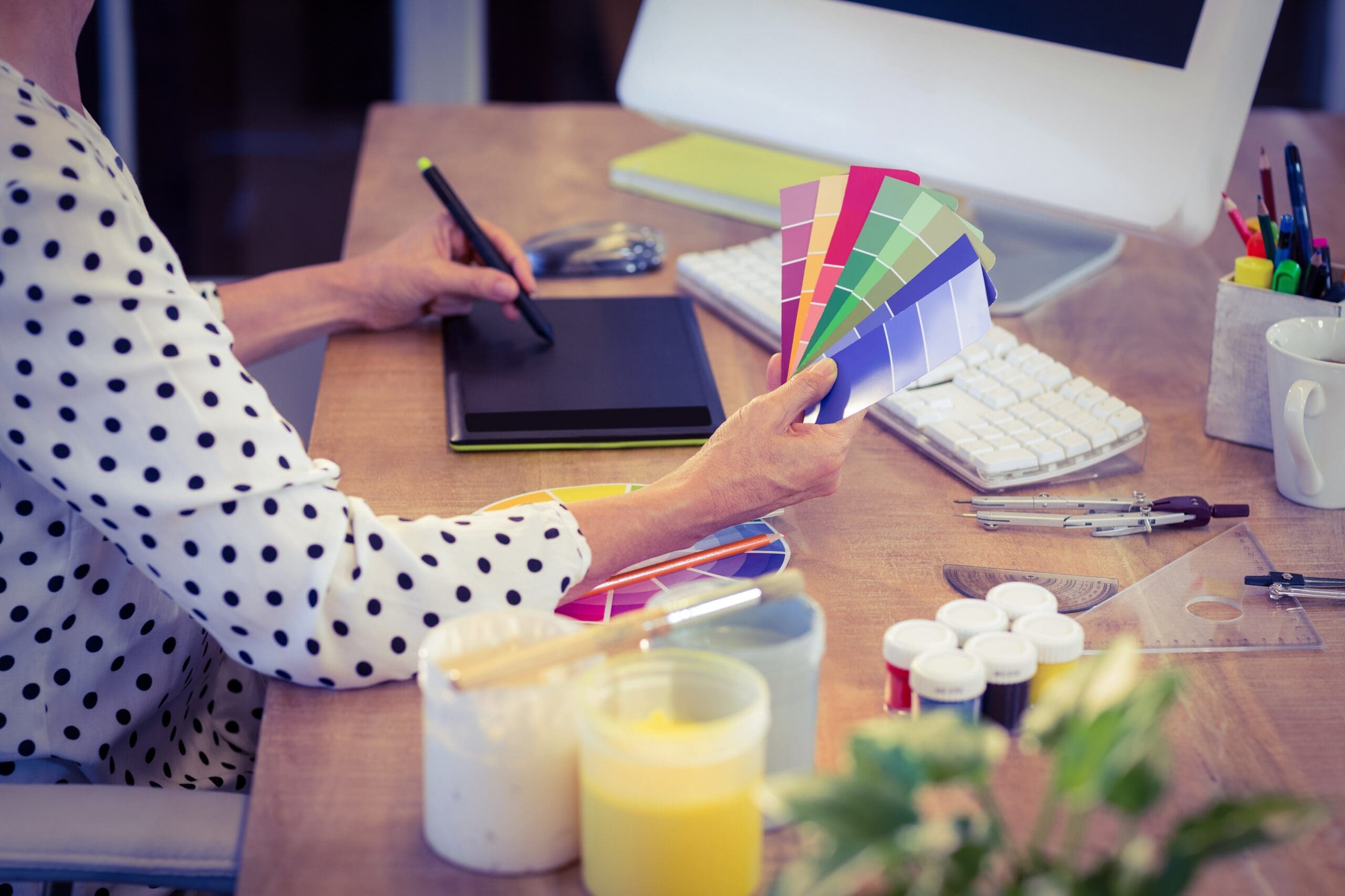 Creative worker at her desk with colour schemes in her hand