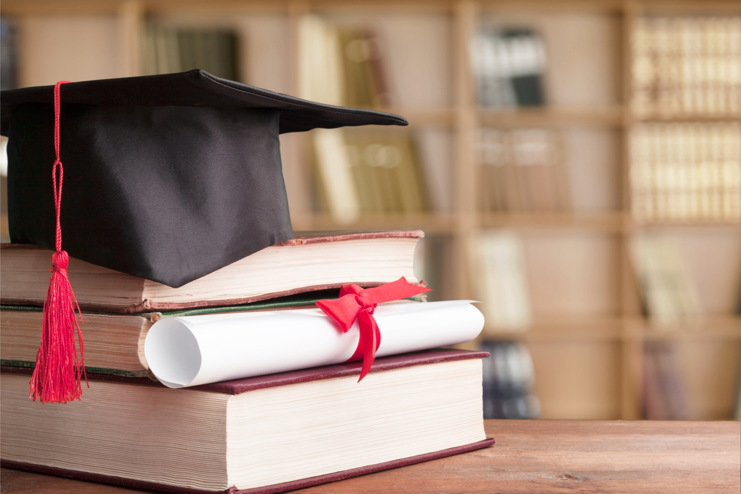 Graduate hat on top of books with degree