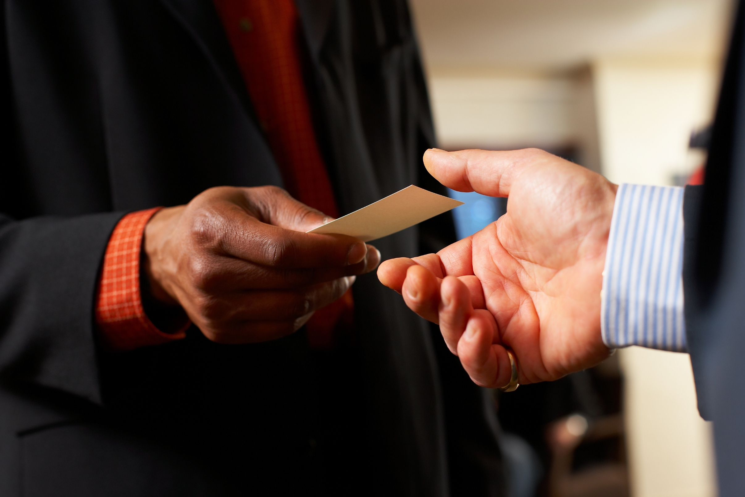 Graphic designer handing card at networking event