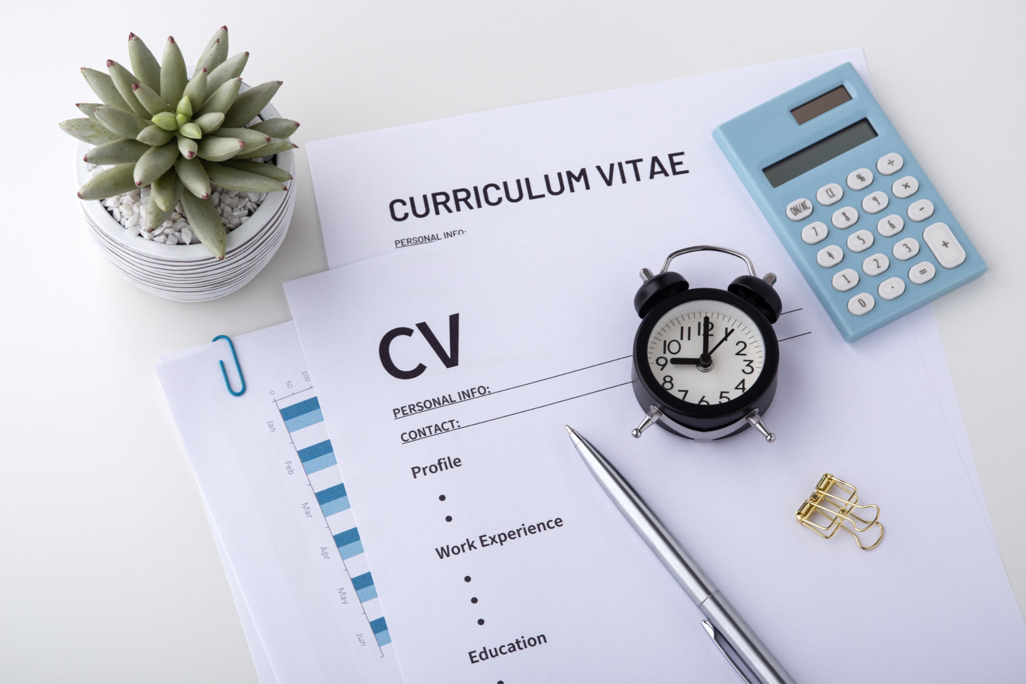 CV template on a desk with pen, calculator and clock on top