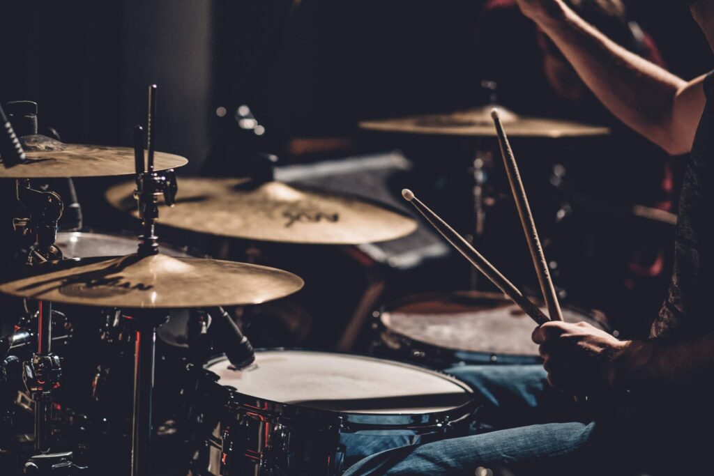 How can I learn to play music in Lincoln? 3 Man playing the drums, practicing