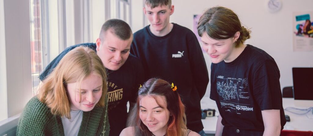 What skills do you need as a content creator? 5 Content Creation students gathered together, watching and providing feedback on content