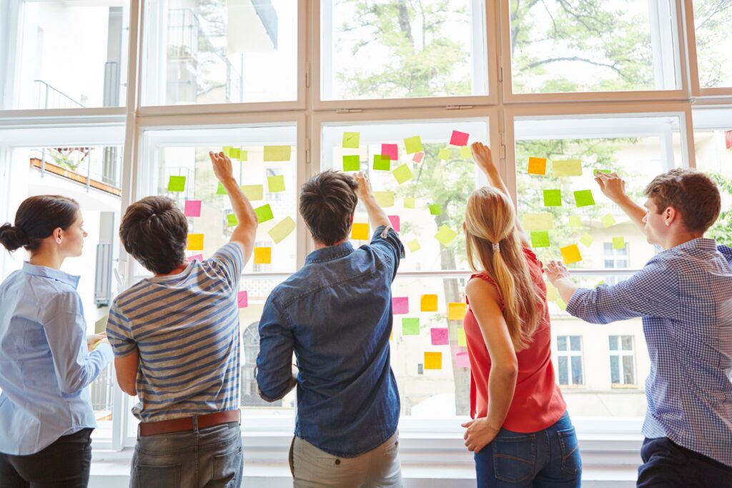 How to film an amazing music video: A step-by-step guide 3 Film students brainstorming using sticky notes