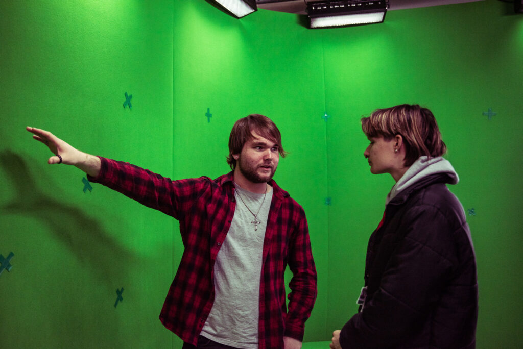 What does a movie producer do? 2 Man teaching using a green screen