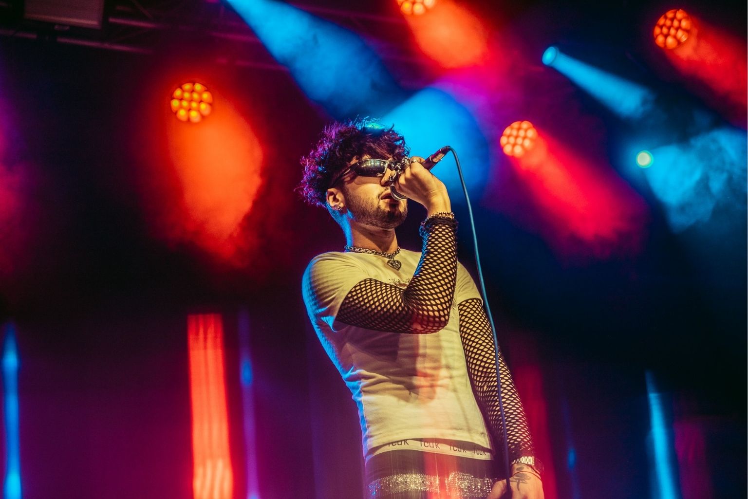 Fear of Marko singer performing on stage in Manchester, with lighting behind him