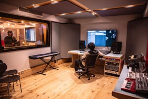 image of a studio with someone at the mic and someone else on the production