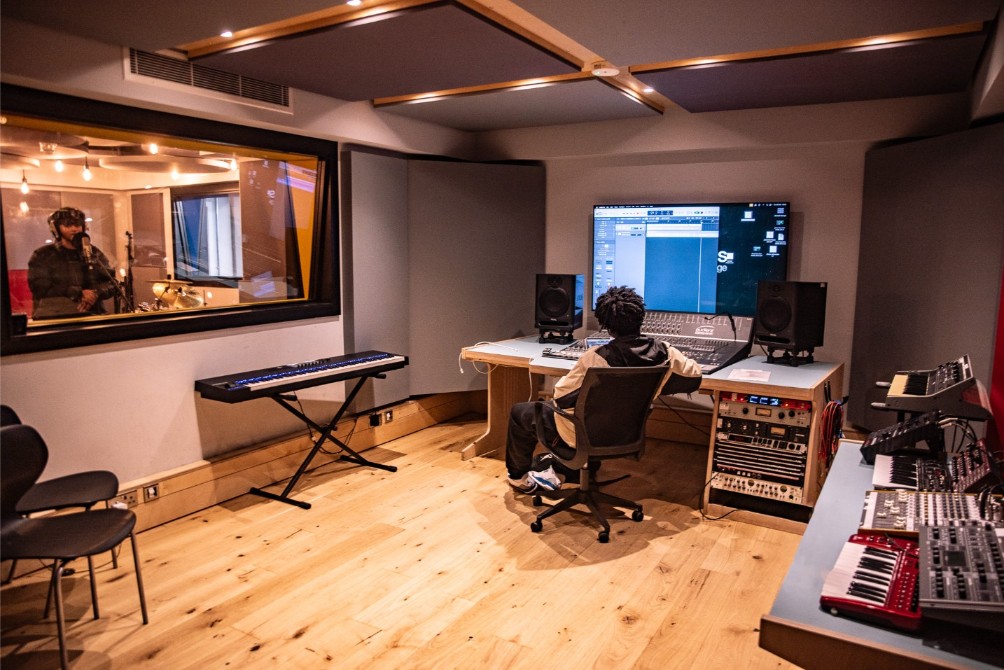 image of a studio with someone at the mic and someone else on the production